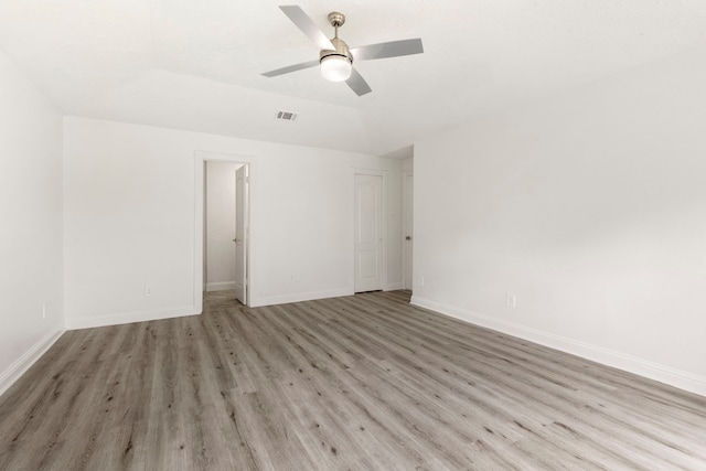 spare room featuring ceiling fan, lofted ceiling, and light wood-type flooring