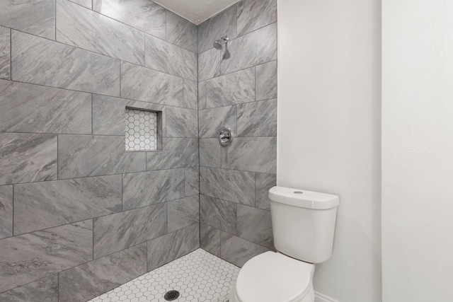 bathroom with toilet and tiled shower