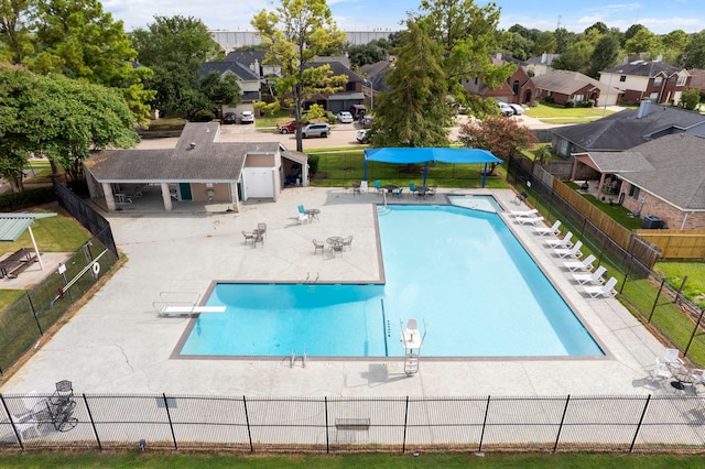 view of swimming pool featuring a patio area and a diving board