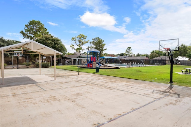 view of sport court with a playground and a yard