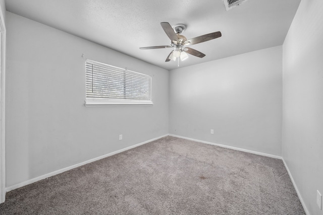 carpeted spare room with ceiling fan and a textured ceiling