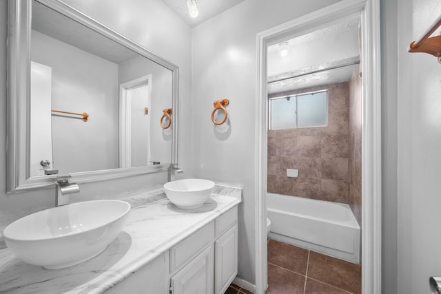 bathroom featuring tile patterned flooring, a textured ceiling, vanity, and tiled shower / bath