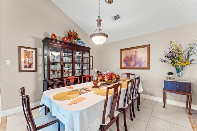 tiled dining room with lofted ceiling