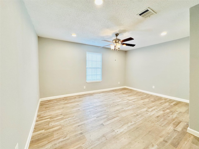 spare room with ceiling fan, light hardwood / wood-style floors, and a textured ceiling