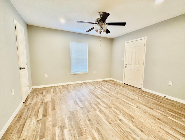 empty room with ceiling fan and light hardwood / wood-style floors