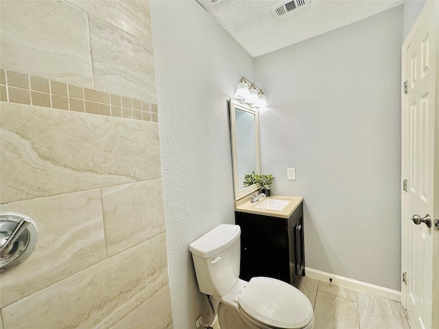 bathroom with toilet, vanity, and a textured ceiling