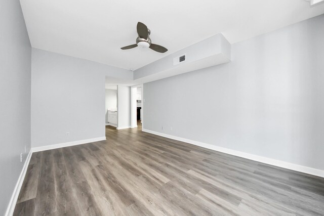 empty room featuring ceiling fan and dark wood-type flooring