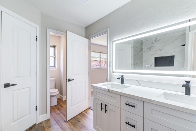 bathroom with toilet, vanity, a shower, and hardwood / wood-style floors