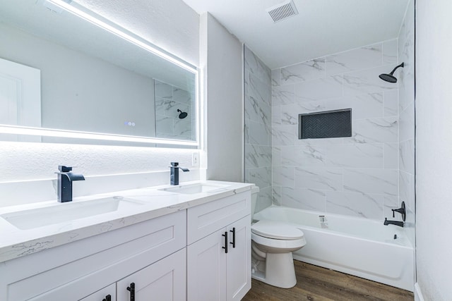 full bathroom featuring toilet, tiled shower / bath, vanity, and hardwood / wood-style flooring