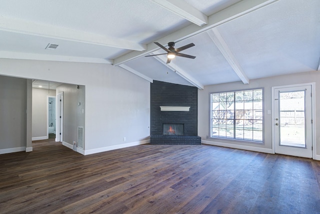 unfurnished living room featuring a brick fireplace, a textured ceiling, dark hardwood / wood-style flooring, and lofted ceiling with beams