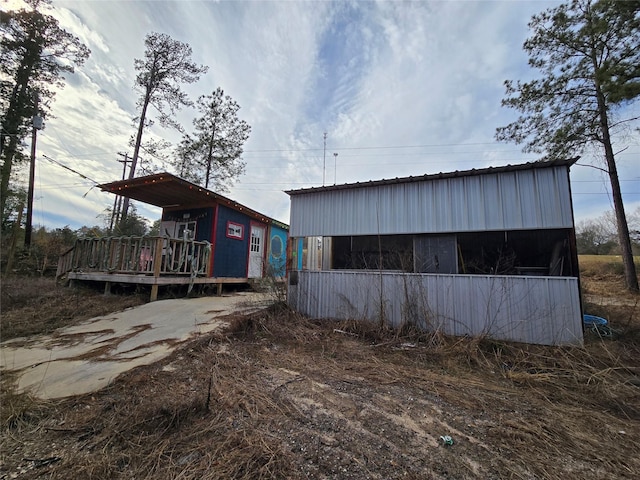 rear view of house featuring a deck and an outbuilding