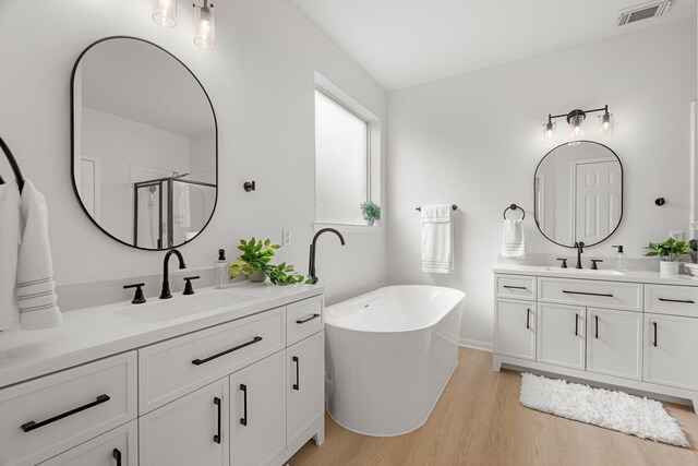 bathroom with separate shower and tub, vanity, and wood-type flooring