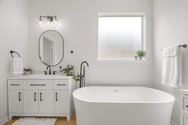 bathroom featuring hardwood / wood-style floors, vanity, and a tub