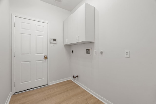 washroom with cabinets, hookup for an electric dryer, gas dryer hookup, hookup for a washing machine, and light hardwood / wood-style floors