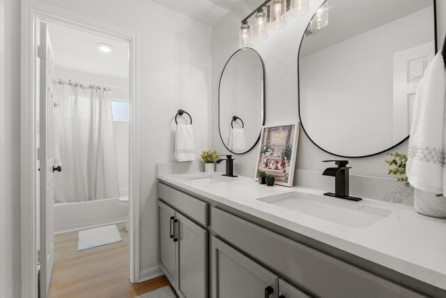 bathroom with shower / tub combo, vanity, and wood-type flooring