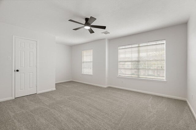 carpeted spare room with ceiling fan