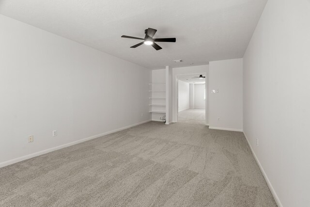 spare room with ceiling fan and light colored carpet