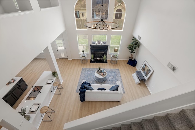 living room with a chandelier, hardwood / wood-style floors, and a towering ceiling