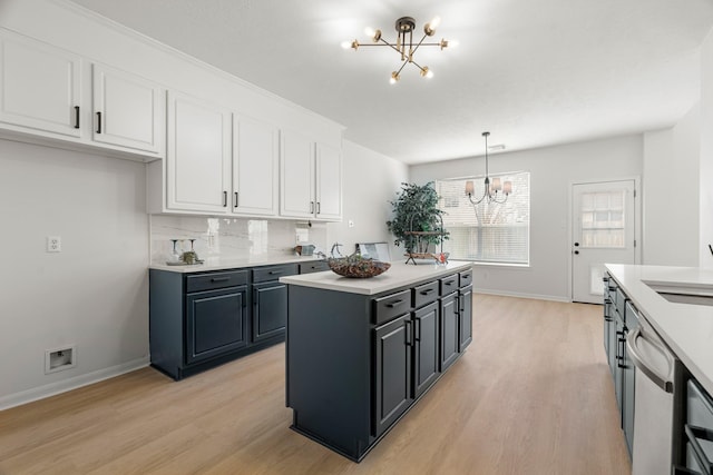 kitchen with a center island, hanging light fixtures, stainless steel dishwasher, a notable chandelier, and white cabinetry