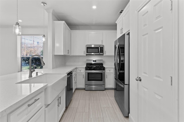 kitchen featuring stainless steel appliances, hanging light fixtures, and white cabinetry