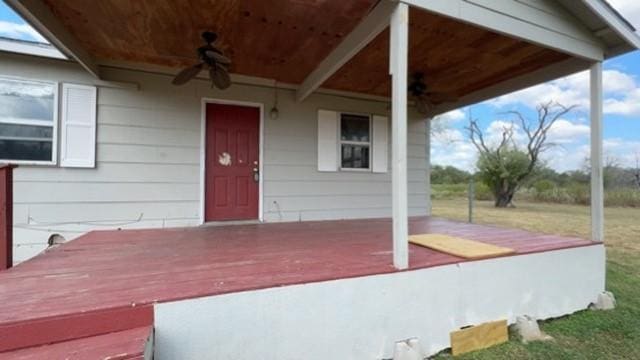 property entrance with ceiling fan and a yard