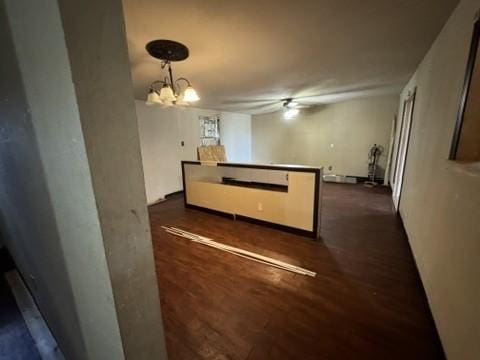 kitchen with pendant lighting, dark wood-type flooring, and an inviting chandelier