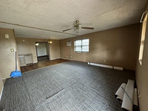 empty room with a textured ceiling, an AC wall unit, and ceiling fan