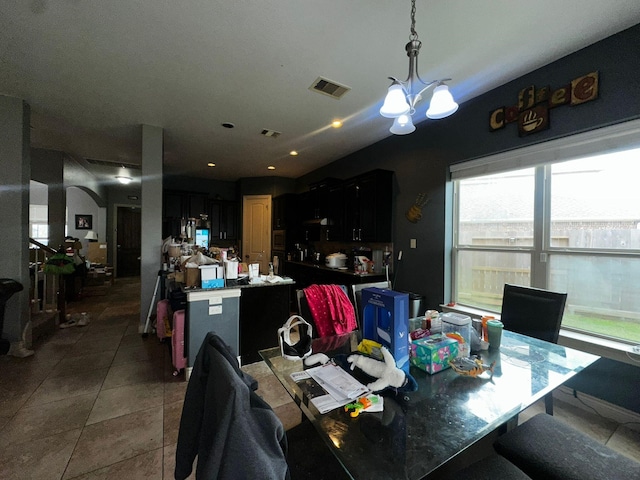 dining area with tile patterned flooring and an inviting chandelier