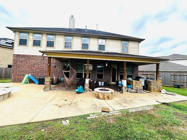 rear view of house featuring a fire pit, a patio area, and exterior kitchen