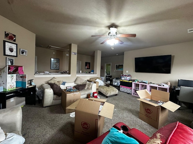 living room featuring carpet, ceiling fan, and a textured ceiling