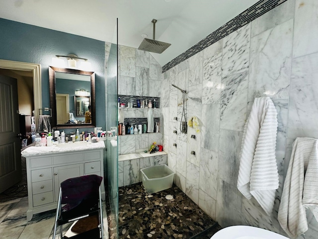 bathroom with tile walls, vanity, vaulted ceiling, and tiled shower