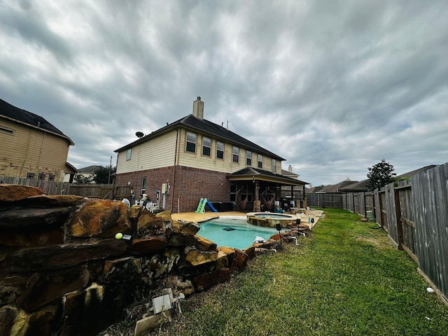 view of pool with a patio area, an in ground hot tub, and a yard