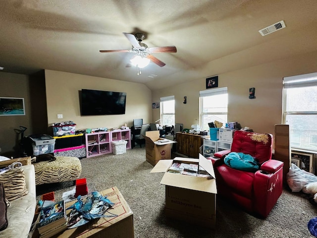 living room featuring ceiling fan, carpet floors, and vaulted ceiling