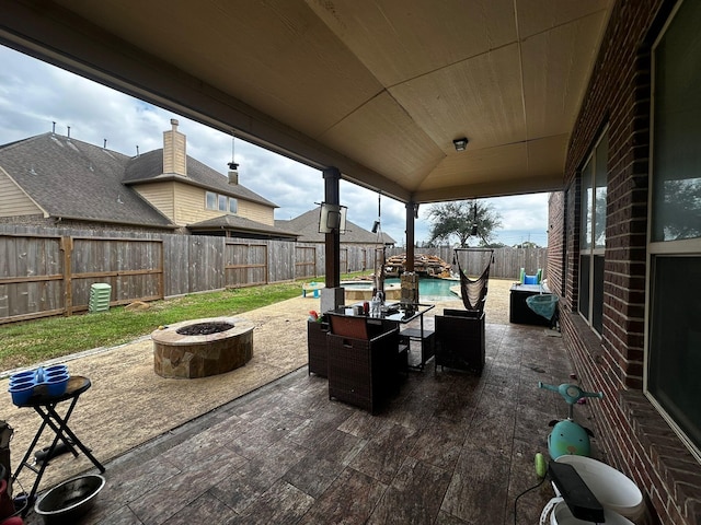 view of patio featuring a fenced in pool and a fire pit