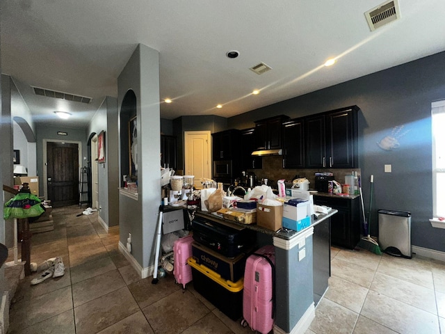 kitchen with built in microwave, a breakfast bar, and light tile patterned floors