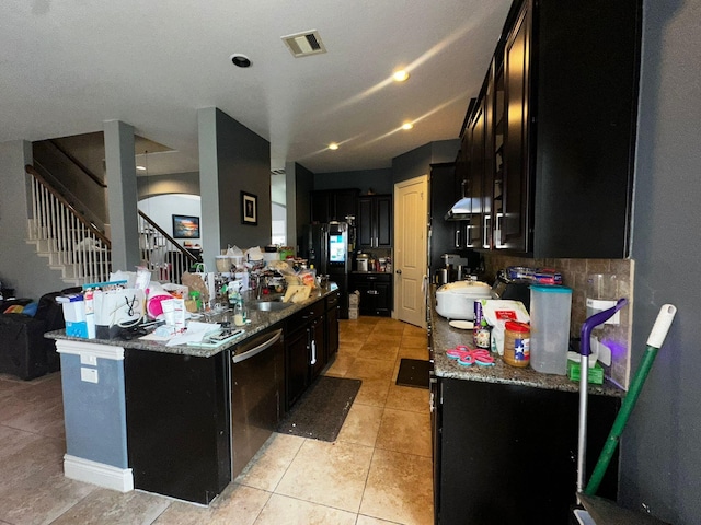 kitchen featuring dishwasher, light tile patterned floors, stone countertops, and black refrigerator