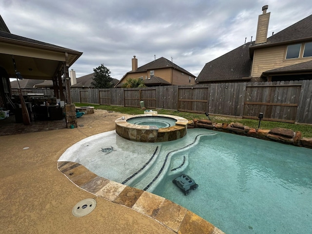 view of pool with a patio area and an in ground hot tub