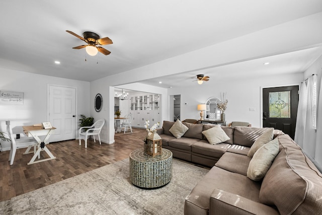 living room featuring hardwood / wood-style floors and ceiling fan with notable chandelier