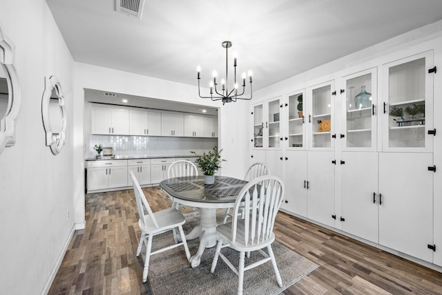 dining area with a chandelier and dark wood-type flooring