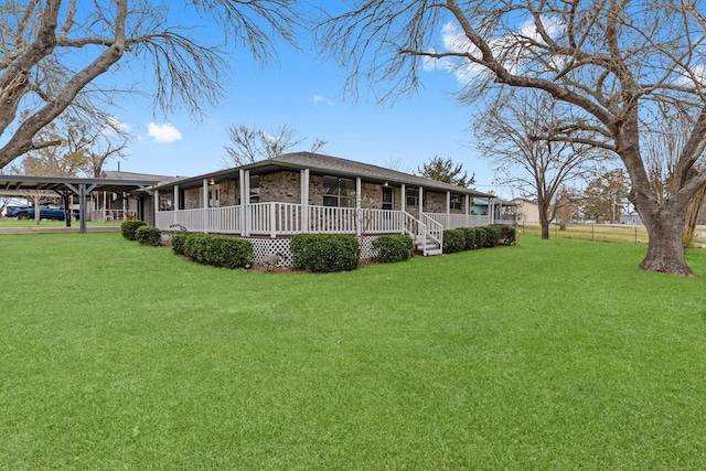 back of property with a lawn, a carport, and a porch