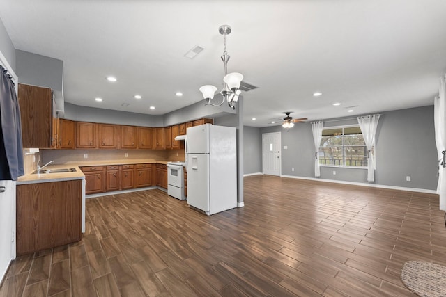 kitchen featuring sink, ceiling fan with notable chandelier, white appliances, and decorative light fixtures