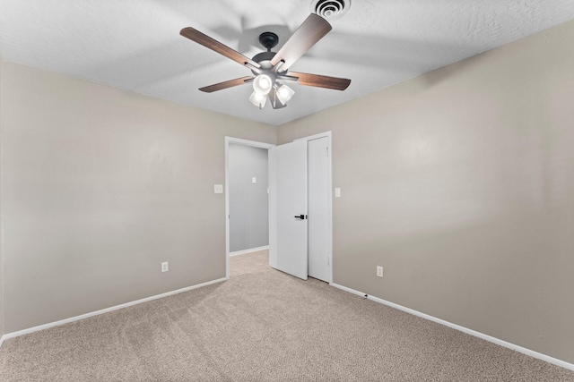 unfurnished room featuring light carpet, a textured ceiling, and ceiling fan