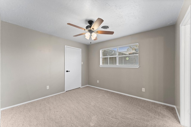 empty room with a textured ceiling, carpet floors, and ceiling fan