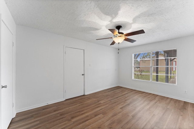 spare room with ceiling fan, wood-type flooring, and a textured ceiling