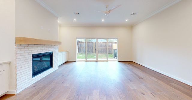 unfurnished living room with crown molding, a fireplace, ceiling fan, and light hardwood / wood-style floors