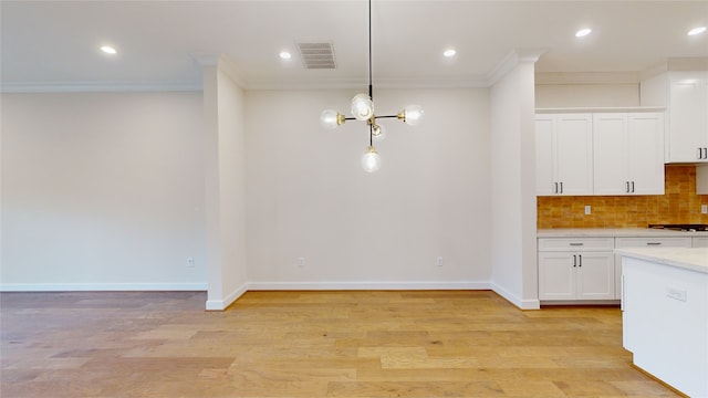 kitchen with crown molding, decorative light fixtures, light wood-type flooring, a notable chandelier, and white cabinetry