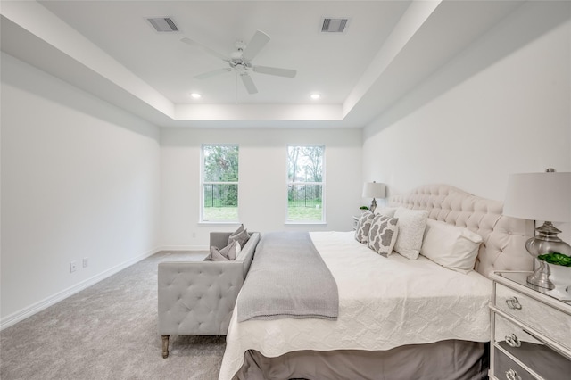 bedroom with ceiling fan, a raised ceiling, and carpet floors