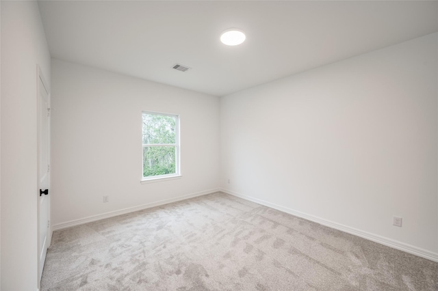 unfurnished room featuring light carpet