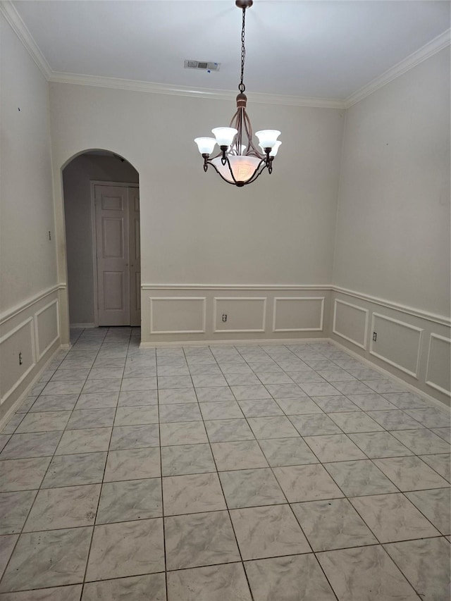 spare room featuring ornamental molding and a notable chandelier