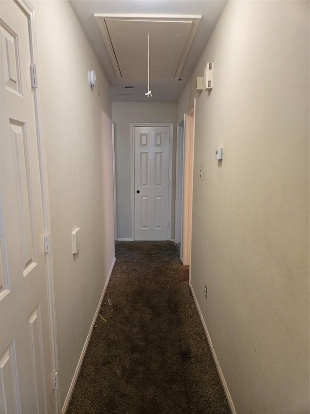 hallway featuring dark colored carpet